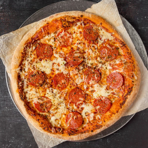 SUPPA'S PIZZA & SUBS pepperoni pizza with melted cheese and herbs on a metal pan.